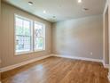 Bright bedroom featuring wood floors, natural light from large windows, and neutral paint for versatile decor at 4082 Adler Cir, Buford, GA 30519