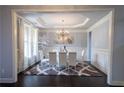 Elegant dining room with a decorative chandelier, white furniture set, and beautiful decor at 552 Warrenton Run Dr, Sugar Hill, GA 30518