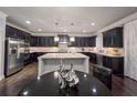 Open concept kitchen features dark cabinets, granite counters and stainless steel appliances at 552 Warrenton Run Dr, Sugar Hill, GA 30518