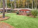 Well-maintained brick home with lush green lawn and mature trees providing shade and privacy at 1868 Fort Valley Sw Dr, Atlanta, GA 30311