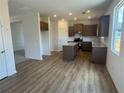 Open-concept kitchen with an island, stainless appliances and hardwood style flooring at 233 Bloomfield Cir, Canton, GA 30114