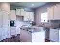 Well-lit kitchen boasts granite counters, island, ample cabinetry, and stainless steel sink at 233 Bloomfield Cir, Canton, GA 30114