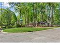 View of the property's exterior showing the large front lawn and mature trees at 2799 Briarglen Dr, Atlanta, GA 30340