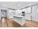 Modern kitchen boasts white cabinets, stainless steel appliances, and a large island at 6108 Marigold Way, Atlanta, GA 30349