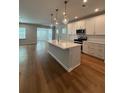 Open-concept kitchen with island, pendant lighting, and stainless steel appliances at 6108 Marigold Way, Atlanta, GA 30349