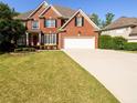Spacious two-story brick home with manicured lawn and driveway leading to a two-car attached garage at 2553 Twilight Vw, Snellville, GA 30078