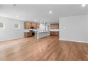 Open-concept living space showcasing wood floors, neutral walls, and a kitchen with an island at 6100 Marigold Way, Atlanta, GA 30349