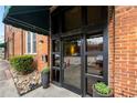 Close-up of the building's entrance with brick walls, glass doors, and potted plants at 1596 Cleveland Ave # 204, Atlanta, GA 30344