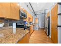 A bright kitchen with stone countertops, wood cabinetry and stainless steel appliances at 1596 Cleveland Ave # 204, Atlanta, GA 30344