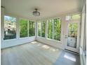 Bright sunroom with beautiful outdoor views, white trim, and light hardwood floors at 5122 Micaela Way, Duluth, GA 30096