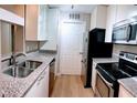 Modern kitchen features stainless steel appliances, granite counters, and white cabinets at 310 Warm Springs Cir, Roswell, GA 30075