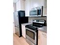 Close up of black and stainless steel kitchen appliances, including microwave and electric oven at 310 Warm Springs Cir, Roswell, GA 30075