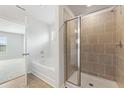 Bathroom featuring a tiled walk-in shower, a soaking tub, and modern fixtures at 7109 Brushwood Bend - Lot 47, Lithonia, GA 30058