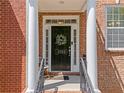 Elegant front entrance featuring a classic black door flanked by white pillars and a lovely seasonal wreath at 1723 Highlands Se Vw, Smyrna, GA 30082