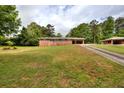 A one story brick house on a large lot with mature trees and a long driveway at 3556 Forest Hill Rd, Powder Springs, GA 30127