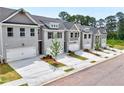 A row of modern townhomes features gray brick, two-car garages, and small, landscaped front yards at 1217 Fern Ridge Ct # 16, Norcross, GA 30093