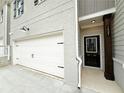 Exterior side view of the home showing the garage, front door, and address at 1227 Fern Ridge Ct # 17, Norcross, GA 30093