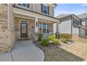Inviting front porch with stone accents, lush landscaping, and a charming entrance, setting the tone for a warm welcome at 1602 Dover Creek Ln, Lawrenceville, GA 30045