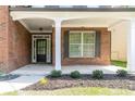 Inviting front porch featuring brick columns, manicured landscaping, and a stylish front door at 351 Chandler Bluff Ct, Grayson, GA 30017
