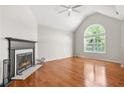 Bright living room boasts a fireplace, hardwood floors and a large window at 3927 Villager Way, Rex, GA 30273