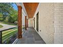 Long covered porch boasting stone flooring, a wooden ceiling, and decorative lighting at 819 Loridans Ne Dr, Atlanta, GA 30342