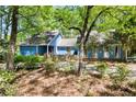 A cozy blue house with a quaint patio, brick foundation, and lush landscaping at 1326 Janmar Rd, Snellville, GA 30078