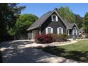 View of home's driveway and attached garage, featuring manicured landscaping and a well-maintained exterior at 545 Chaseridge Dr, Mcdonough, GA 30253