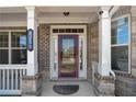 Charming front door with sidelights and transom window, flanked by white columns and manicured landscaping at 4250 Harrison Lndg, Cumming, GA 30041