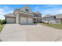 Large concrete driveway leads to the three-car garage of this two-story home with manicured lawn at 4250 Harrison Lndg, Cumming, GA 30041