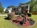 Charming two-story brick home featuring manicured lawn and a decorative flower garden in the front yard at 6010 Silver Lace Nw Ln, Acworth, GA 30101