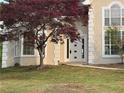 Front entrance of stucco home with an arched front door and manicured lawn at 9454 Lakeview Ct, Douglasville, GA 30135
