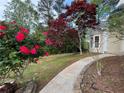 Landscaped yard with beautiful flower bushes and a concrete walkway at 9454 Lakeview Ct, Douglasville, GA 30135