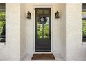 Elegant front door framed by stylish sconces and a decorative wreath, set against a white brick facade at 1395 Oconee Ne Pass, Brookhaven, GA 30319