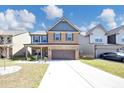 Charming two-story brick home with a welcoming front porch and a well-manicured lawn at 2375 Walker Dr, Hampton, GA 30228