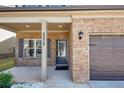 Inviting front porch with brick accents, classic columns, and a stylish entry door at 2375 Walker Dr, Hampton, GA 30228