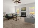 Bright living room with neutral carpet, a ceiling fan, and a fireplace, creating a cozy atmosphere at 5209 Carrington Park Dr, Powder Springs, GA 30127