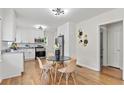 Eat-in kitchen featuring stainless steel appliances, white cabinets, granite countertops, and light wood floors at 561 Allendale Dr, Decatur, GA 30032