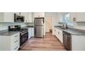 Well-lit kitchen with granite counters, stainless appliances, and stylish wood-look flooring at 1718 Country Park Way, Lawrenceville, GA 30043