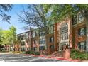 Brick building with a large arched entry and stairs, landscaping with lush trees and bushes at 23101 Plantation Ne Dr, Atlanta, GA 30324
