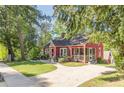 Quaint red home featuring a screened-in porch, concrete driveway, and inviting curb appeal at 2733 Winburn Ter, East Point, GA 30344