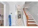 Bright foyer featuring tile flooring, staircase with white risers and wooden handrail at 2958 Paul Harris Rd, Dallas, GA 30157