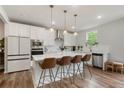 Modern white kitchen featuring a large island with seating, stainless steel appliances, and sleek countertops at 13 Oakside Nw Ct, Cartersville, GA 30121