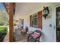 Inviting covered porch with seating area, decorative shutters, and a vintage-style lantern at 1608 Drakes Dr, Jonesboro, GA 30236