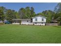 Charming white brick home with well-manicured lawn and covered carport at 3935 Manor House Dr, Marietta, GA 30062