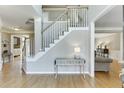 Inviting foyer showcasing hardwood floors, staircase with white railings, and a stylish console table at 1315 Chattahoochee Run Dr, Suwanee, GA 30024