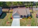 An aerial view of a single-story home showcasing its neat landscaping, fenced backyard, and inviting front porch at 6550 Lantana Village Way, Cumming, GA 30028