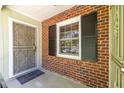 Close-up of a brick-clad front porch with an ornate security door and black shutters, blending classic charm at 1740 Fairbanks Sw St, Atlanta, GA 30310