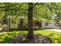 A quaint residence nestled behind a mature tree, showcasing a well-maintained lawn and inviting curb appeal at 1740 Fairbanks Sw St, Atlanta, GA 30310