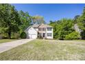 Charming two-story home featuring a brick and white facade, lush lawn, and a basketball hoop by the driveway at 5108 Staplehurst Ln, Woodstock, GA 30189