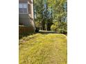 An expansive backyard with mature trees and an overgrown lawn at 7027 Grinder Drive, Austell, GA 30168